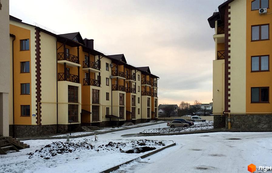 Житловий комплекс Віденська брама. Зовнішній вигляд багатоповерхових будинків з балконами та парковкою. Навколо новобудов розташована прибудинкова територія зі снігом.