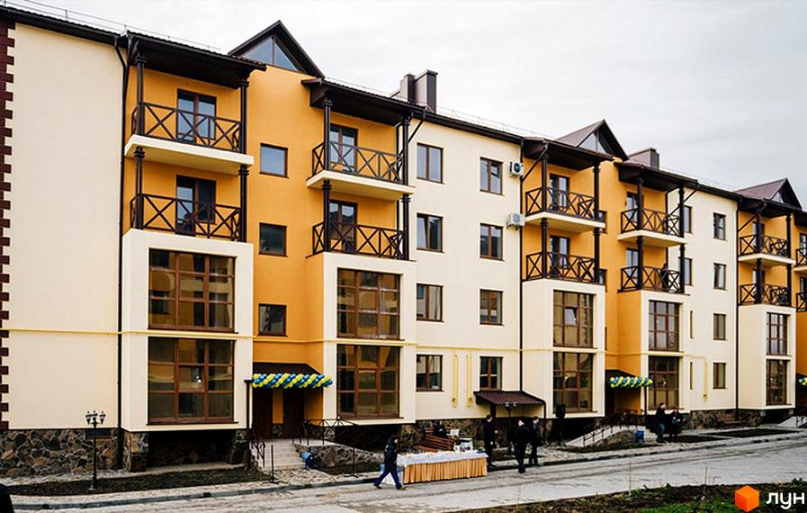 Зовнішній вигляд фасаду житлового комплексу Віденська брама з балконами та вікнами. Прибудинкова територія з людьми та столиком.