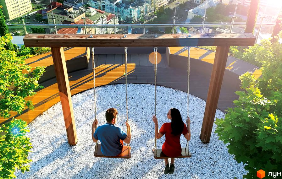 Житловий комплекс Royal Tower: пара закоханих на гойдалках на даху з видом на місто. Прибудинкова територія з деревами та білим гравієм.