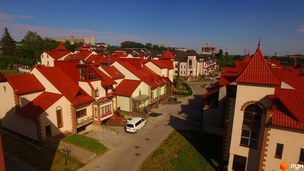 Житловий комплекс Віденська брама: фасади будинків з червоними черепичними дахами та прибудинкова територія з дорогою та зеленню.