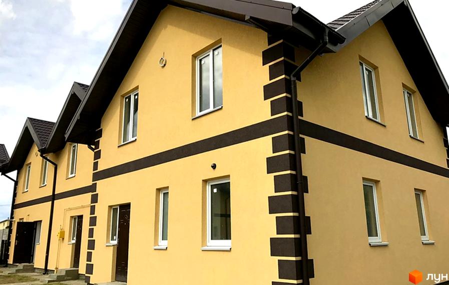 Зовнішній вигляд таунхаусів Монтевіль з жовтим фасадом та темними декоративними елементами. На зображенні видно вікна та двері будинків.