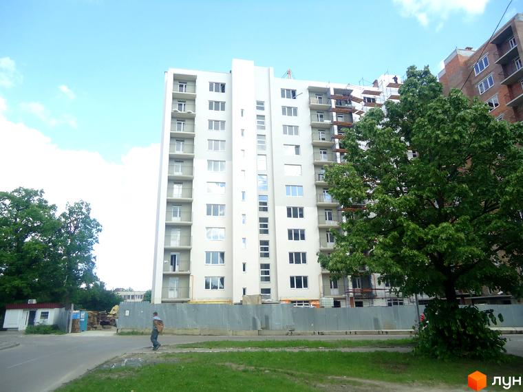 Сучасний житловий комплекс на вул. Кульпарківська, 156, з білим фасадом та балконами. Поруч зелені дерева та будівельний майданчик.
