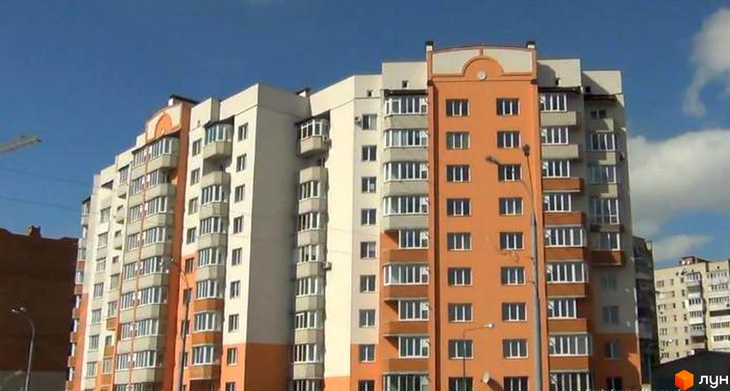 Житловий комплекс „Вишенька“ – багатоповерховий будинок з помаранчевими та білими фасадами, балконами та великою кількістю вікон.