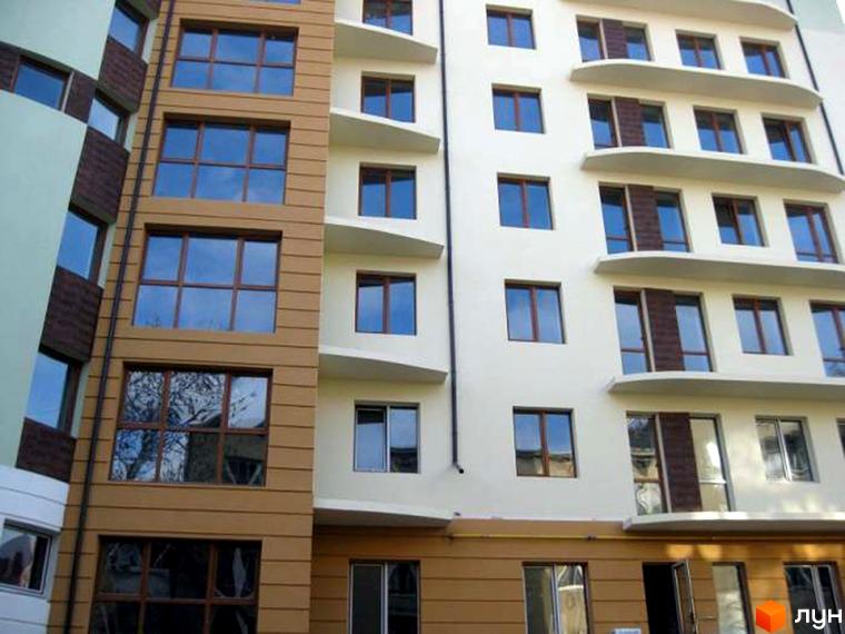 Фасад новобудови на вул. Коциловського, 13. Багатоповерховий будинок з коричневими та світлими елементами, великими вікнами.