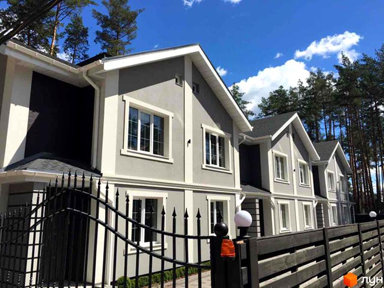 Зображення сторінки житлового комплексу Pacific Park. На фото будинки з сірими фасадами, білими вікнами та дахами. Перед будинками розташований чорний кований паркан.