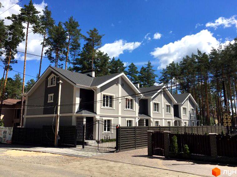 Зображення таунхаусів в житловому комплексі Pacific Park. На фото видно будинки з сірими фасадами та чорними дахами, огороджені парканом. Навколо будівель ростуть дерева.