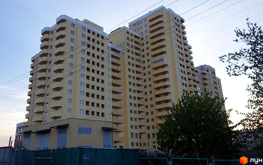 Житловий комплекс на вул. Євгена Харченка, 47-59, з жовтою фасадною обробкою та балконами. Прибудинкова територія з зеленими насадженнями.