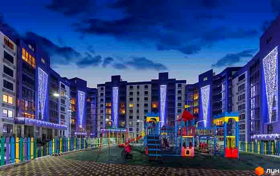 Житловий комплекс Аметист з підсвіченими фасадами та дитячим майданчиком у вечірній час. Сучасна архітектура та освітлення створюють затишну атмосферу.