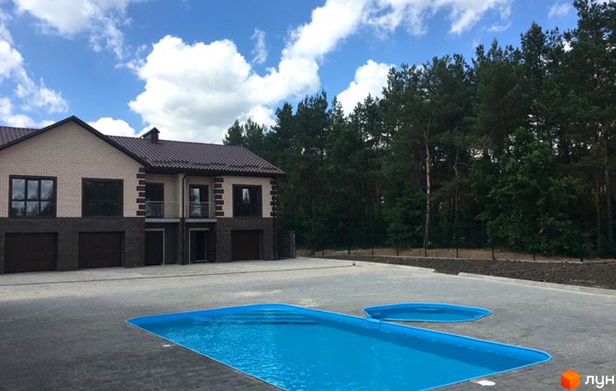 Таунхауси Green Villa з цегляним фасадом та коричневим дахом. На прибудинковій території розташований басейн з блакитною водою.