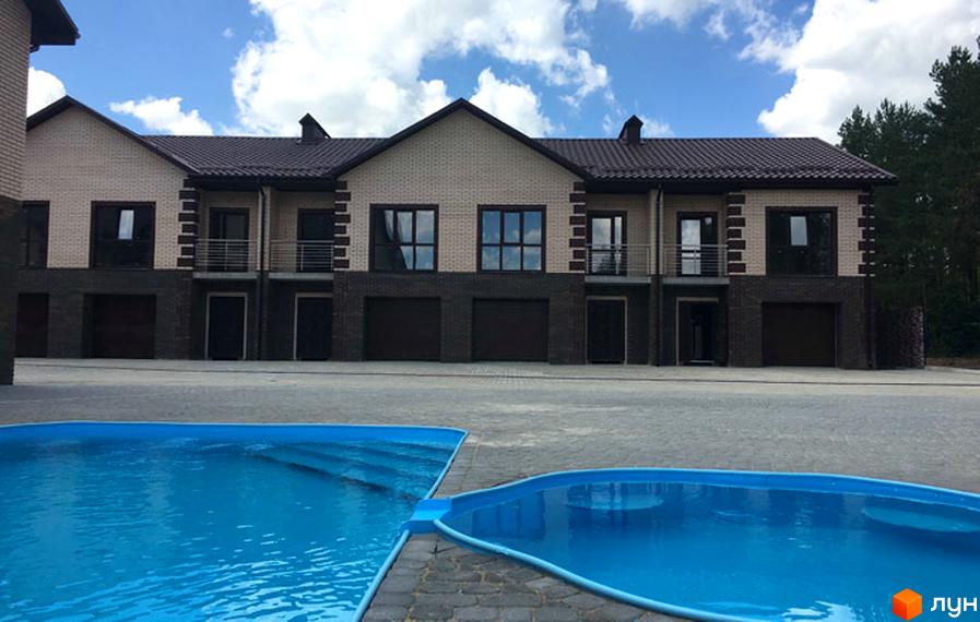 Таунхауси Green Villa з цегляним фасадом та балконами. Поруч розташований басейн з блакитною водою та сходами.