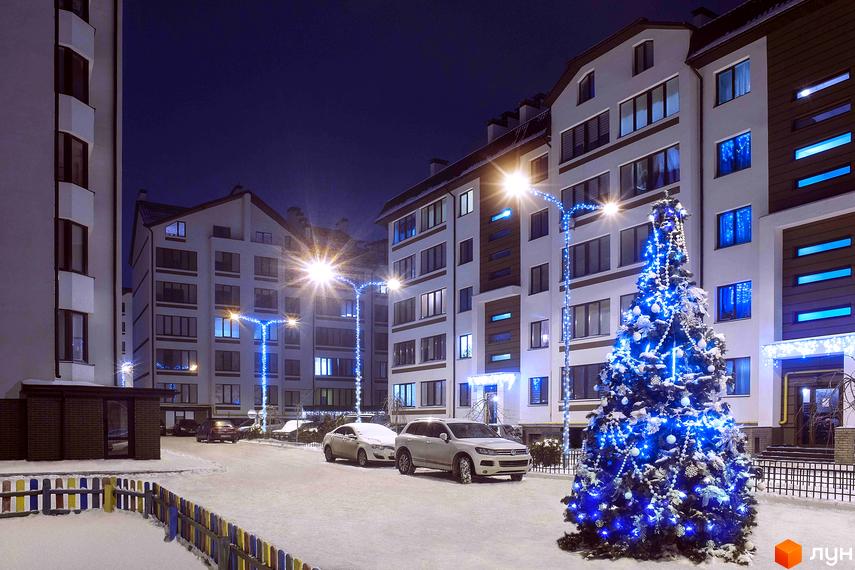 Житловий комплекс Празький квартал взимку. Новобудова з підсвіченою ялинкою та святковими гірляндами на прибудинковій території.