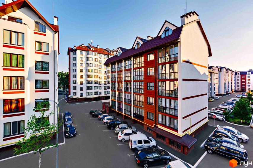 Житловий комплекс Празький квартал. Багатоквартирні будинки з червоними дахами та білими фасадами, парковка з автомобілями.