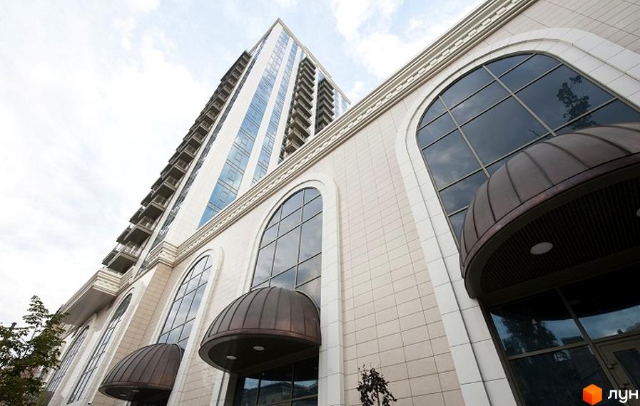 Житловий комплекс Арт Холл з великими вікнами та сучасним фасадом. Прибудинкова територія озеленена та облаштована для відпочинку.