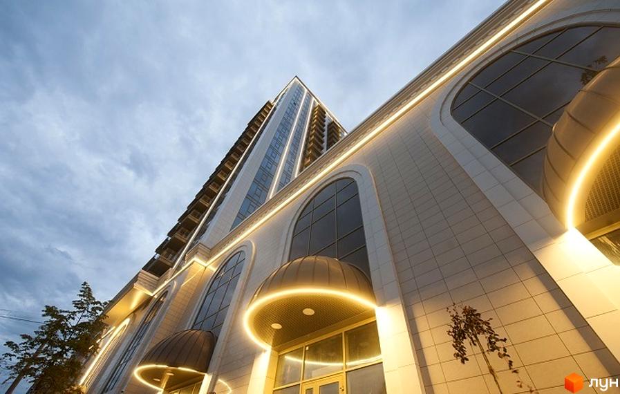 Сучасний клубний будинок 'Арт Холл' з великими вікнами та підсвічуванням. Прибудинкова територія озеленена деревами.