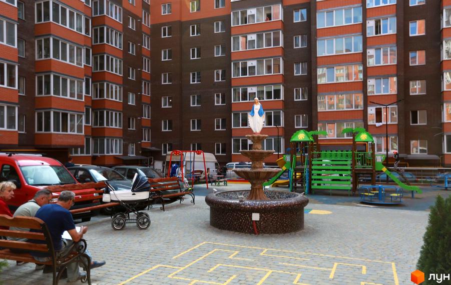 Житловий комплекс Галицький Лев: багатоповерховий будинок з цегляним фасадом та заскленими балконами. У дворі фонтан, дитячий майданчик і зони відпочинку.