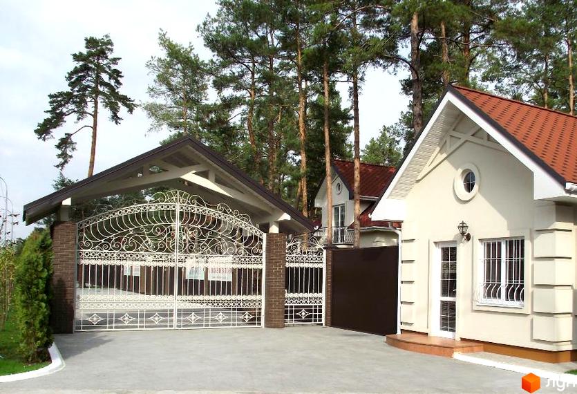 Резиденція AlpenPark: вишуканий фасад будинку та ковані ворота з навісом. Огляд новобудови та прибудинкової території.