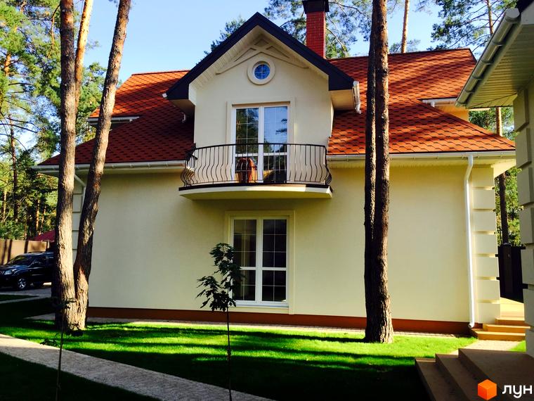 Резиденція AlpenPark – двоповерховий будинок з червоним дахом та балконом. Навколо будинку доглянутий газон та дерева.