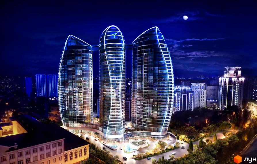 Taryan Towers - три хмарочоси незвичайної форми з підсвіткою вночі. Навколо новобудови розташована доглянута прибудинкова територія з деревами та фонтаном.