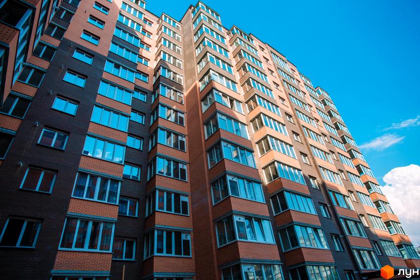 Багатоповерховий будинок Житлового комплексу Олександрівський 1 з комбінованим цегляним фасадом та заскленими балконами.