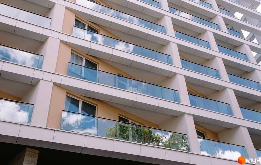 Зовнішній вигляд будинку у Житловому комплексі „Гоголівська, 47“ з балконами та великими вікнами. Архітектура комплексу.