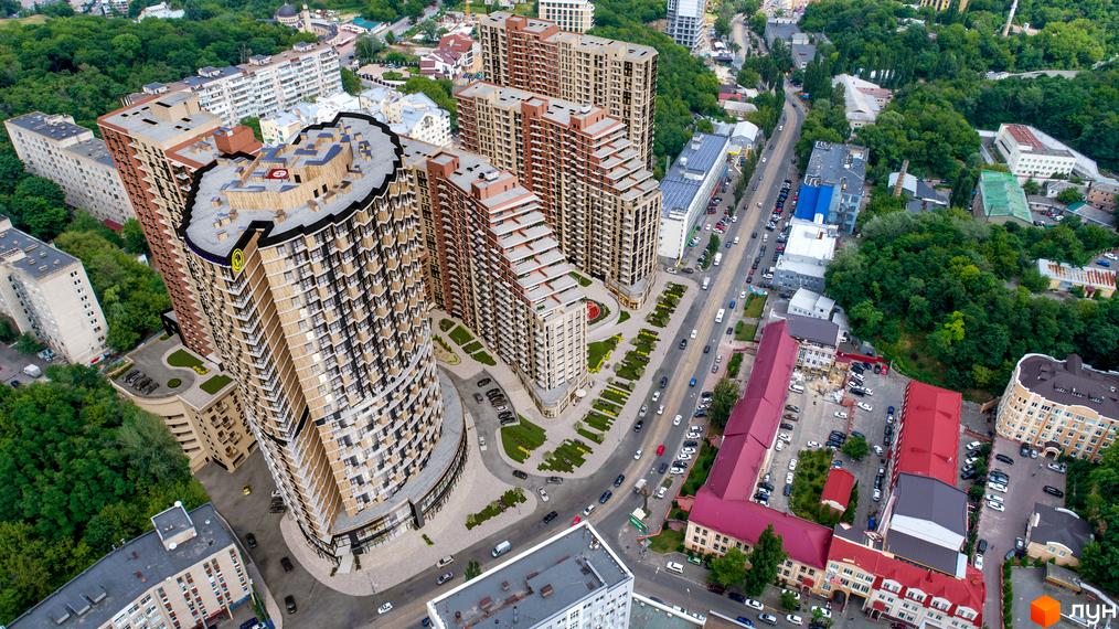 Житловий комплекс Mirax з унікальною архітектурою та терасовими схилами, що доповнюється доглянутою прибудинковою територією з зеленими зонами та місцями для відпочинку.