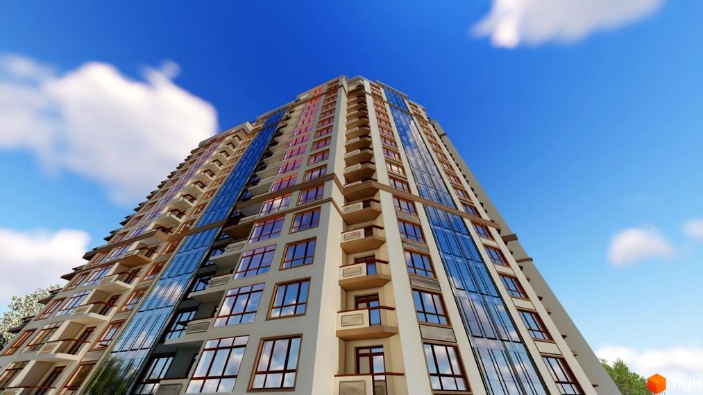 Житловий комплекс Гетьманський Бровари зі світлим фасадом, коричневими вікнами та синім склінням. Навколо видно зелені насадження та небо.