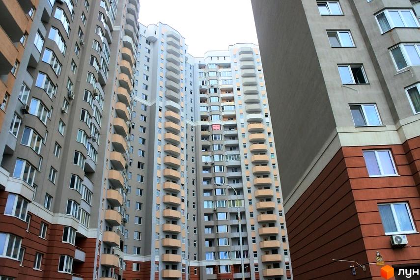Житловий комплекс Коцюбинський: багатоповерхові будинки зі світлими фасадами, коричневими нижніми поверхами та балконами. Вигляд на житлову забудову.
