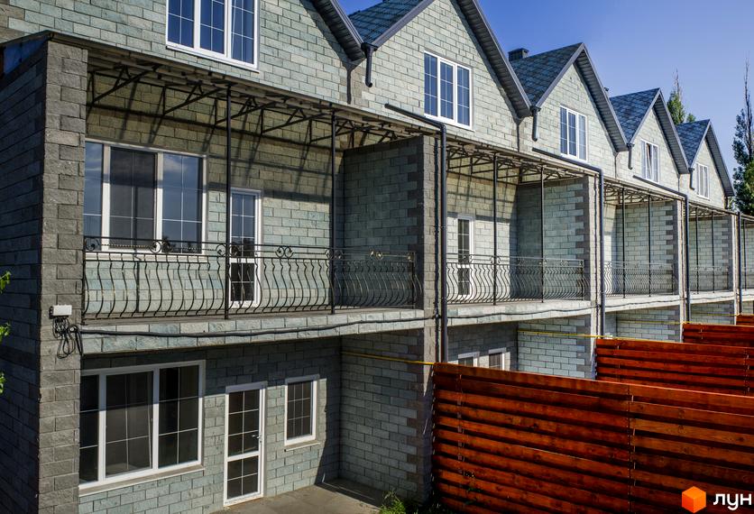 Зображення таунхаусів у Житловому комплексі „На Байкальській“. Двоповерхові будинки з балконами та сірими стінами, видно частину дерев'яного паркану.