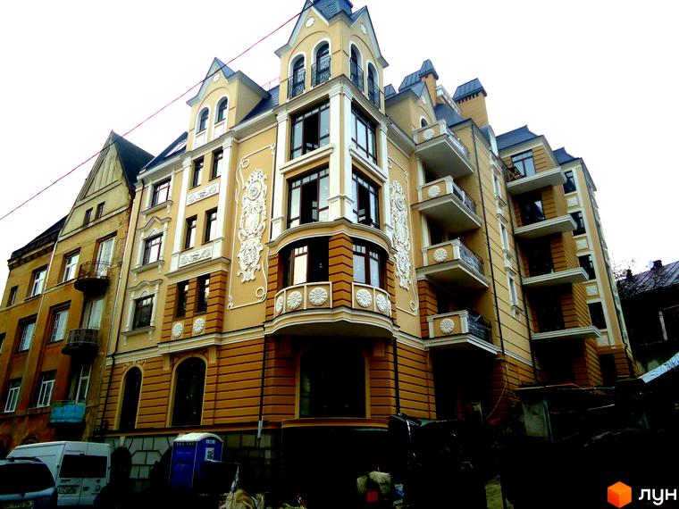 Елегантна новобудова на вулиці Лисенка, 57, з жовтим фасадом та вишуканим декором. Будинок має багато балконів та вікон, що створюють привабливий зовнішній вигляд.