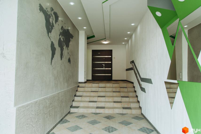 Інтер'єр під'їзду Житлового комплексу Водограй з мапою світу на стіні, сходами та дзеркальними елементами декору.