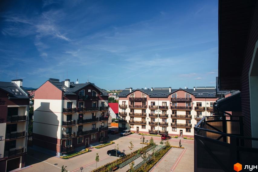 Житловий комплекс Едельвейс з балконами та терасами. На території комплексу є парковка та зелені насадження.