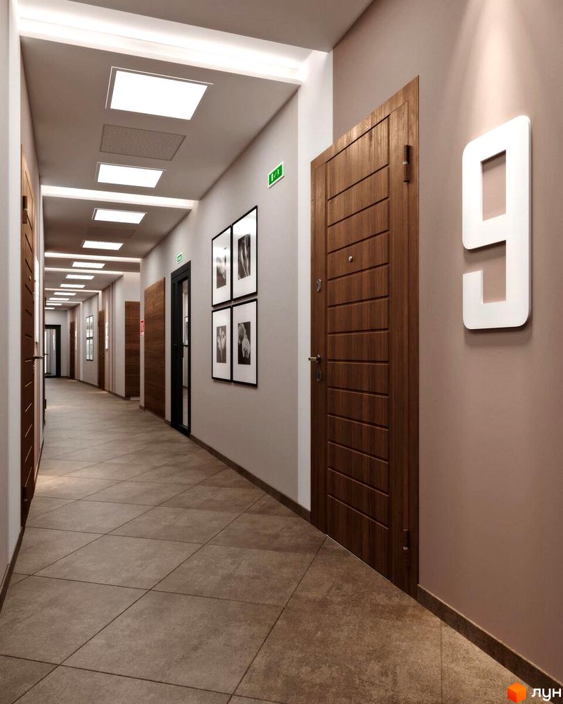 Коридор у новобудові з дверима з дерев'яними панелями та великим номером 9 на стіні. На стелі розміщені квадратні світильники, а підлога викладена плиткою.