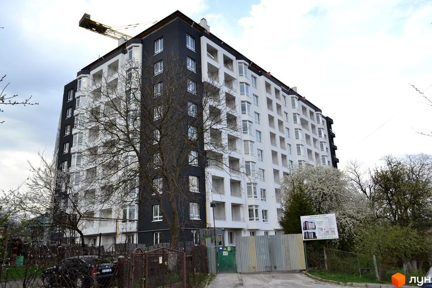 Житловий комплекс Kaiser – це багатоповерхова новобудова з біло-чорним фасадом та балконами. Навколо будинку розташовані дерева та огорожа.