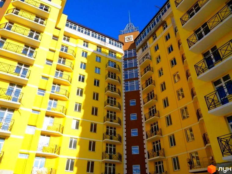 Житловий комплекс Велесгард у жовтому кольорі з балконами та вікнами. Новобудова з сучасною архітектурою.