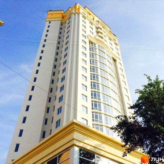 Фото висотної будівлі Житлового комплексу Obolon Tower з великою кількістю вікон. Вигляд на фасад будинку та частину прилеглої території.