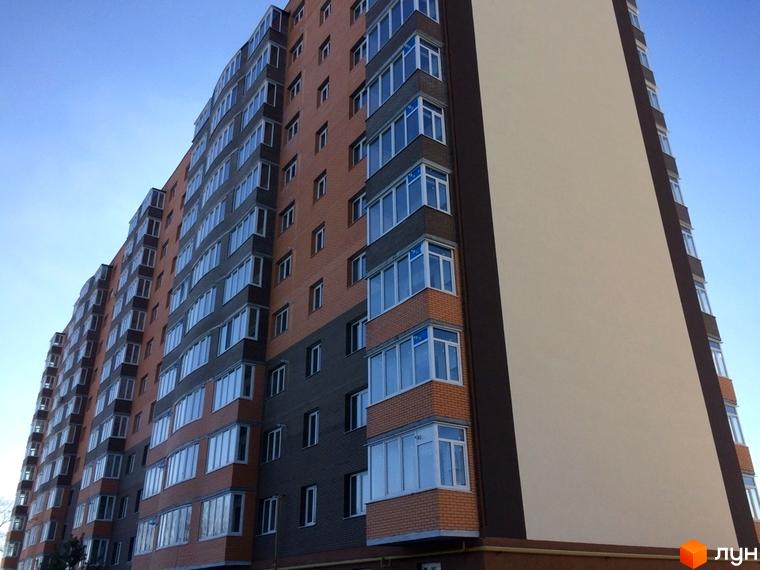 Зображення фасаду багатоповерхового будинку в Житловому комплексі Перший Парковий квартал. Вигляд новобудови з великою кількістю вікон та балконів.