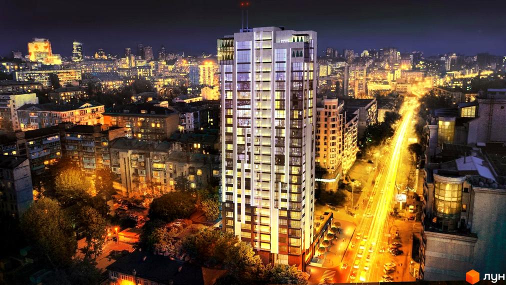 Висотна будівля ЖК AuRoom вночі з підсвічуванням. Навколо будівлі видно міську забудову та освітлену дорогу з автомобілями.