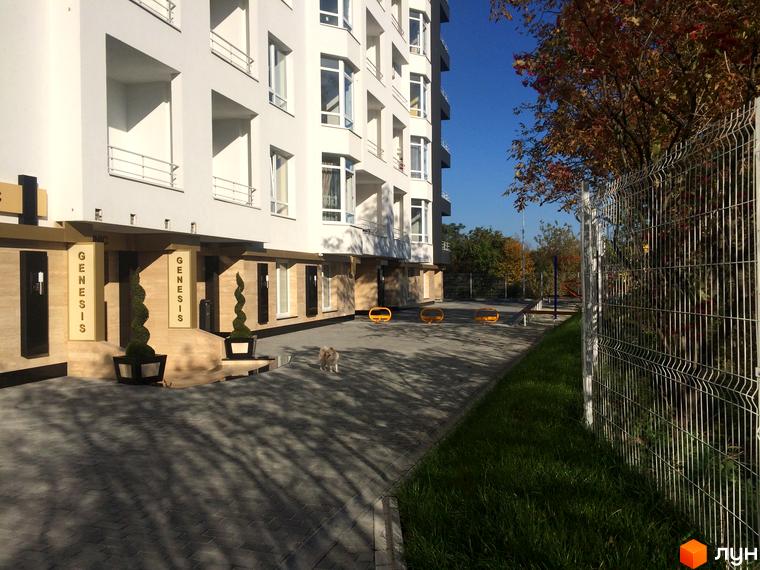 Новобудова ЖК Kaiser з білим фасадом та вікнами, прибудинкова територія з бруківкою та зеленню.