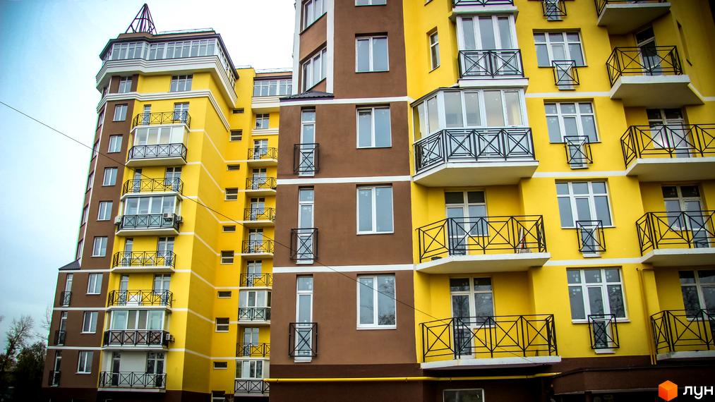 Житловий комплекс Велесгард - фасади будівель з жовтими та коричневими елементами, балконами та великими вікнами. Зовнішній вигляд новобудови.