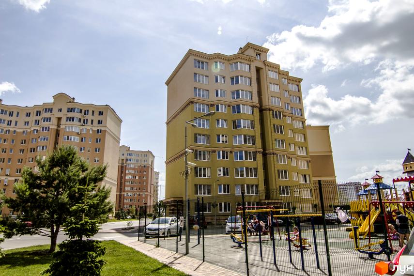 Житловий комплекс Софія Сіті. Сучасні багатоповерхові будинки з великою кількістю вікон та дитячим майданчиком на прибудинковій території.