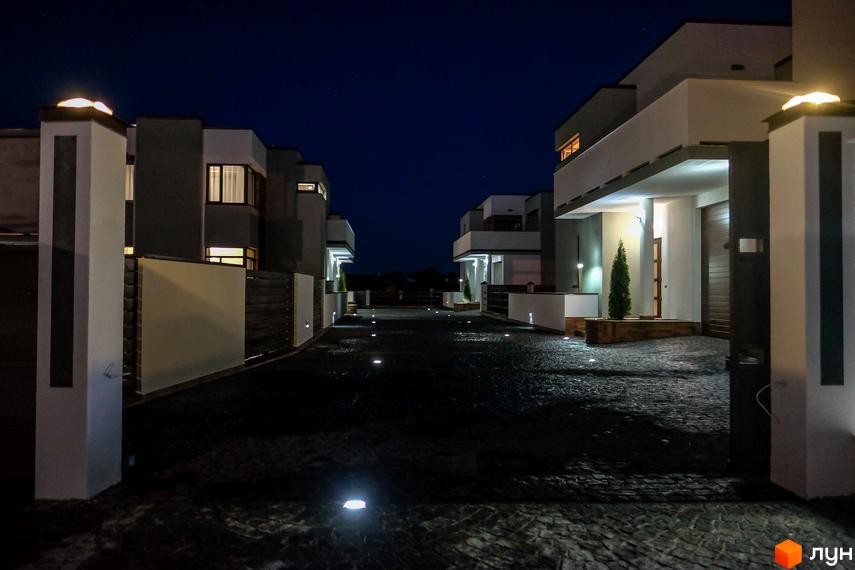 Котеджне містечко КМ Riviera вночі. Сучасні будинки з підсвіченою територією та доріжками.