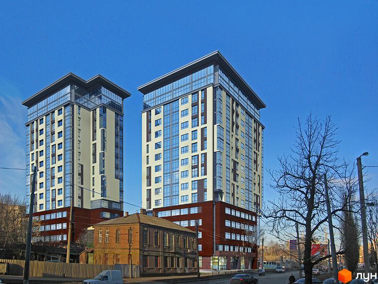 Житловий комплекс Кристал - це дві висотні будівлі з панорамними вікнами та скляними фасадами. На передньому плані видно старі будівлі та дорогу з автомобілями.