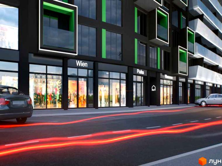 Новобудова Avalon з фасадом чорного кольору та зеленими елементами. На першому поверсі розташовані магазини, перед будівлею проїжджає автомобіль.