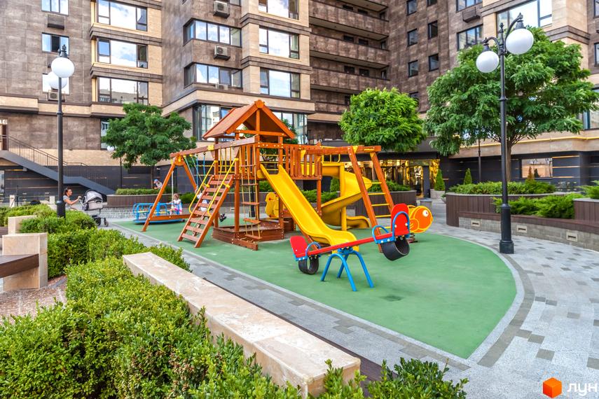Житловий комплекс Obolon Residences з багатоповерховими будинками. На прибудинковій території облаштований дитячий майданчик та зелені насадження.