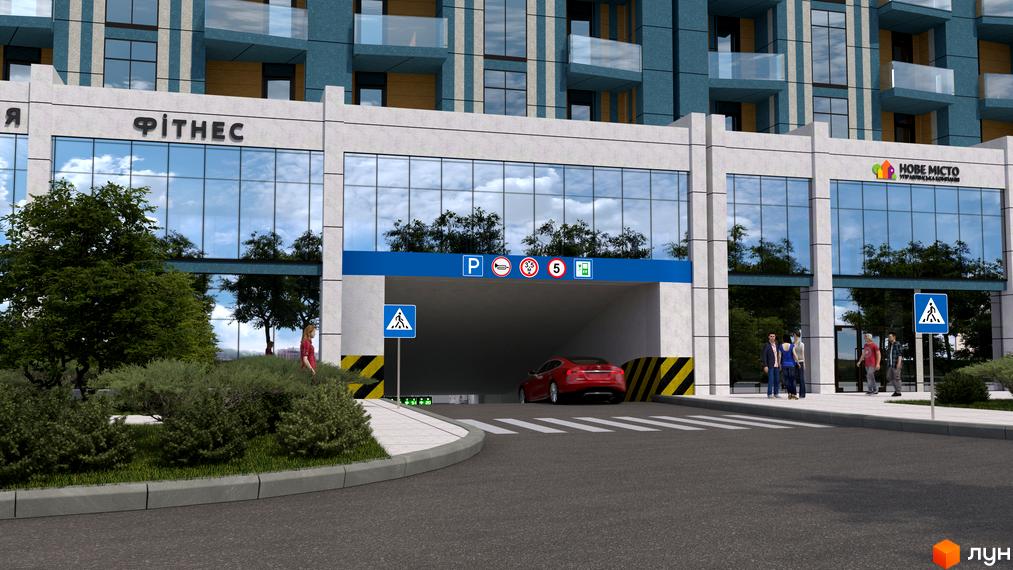 Фасад будівлі з скляними вікнами та входом в підземний паркінг. На території розташовані зелені насадження та пішохідні зони.