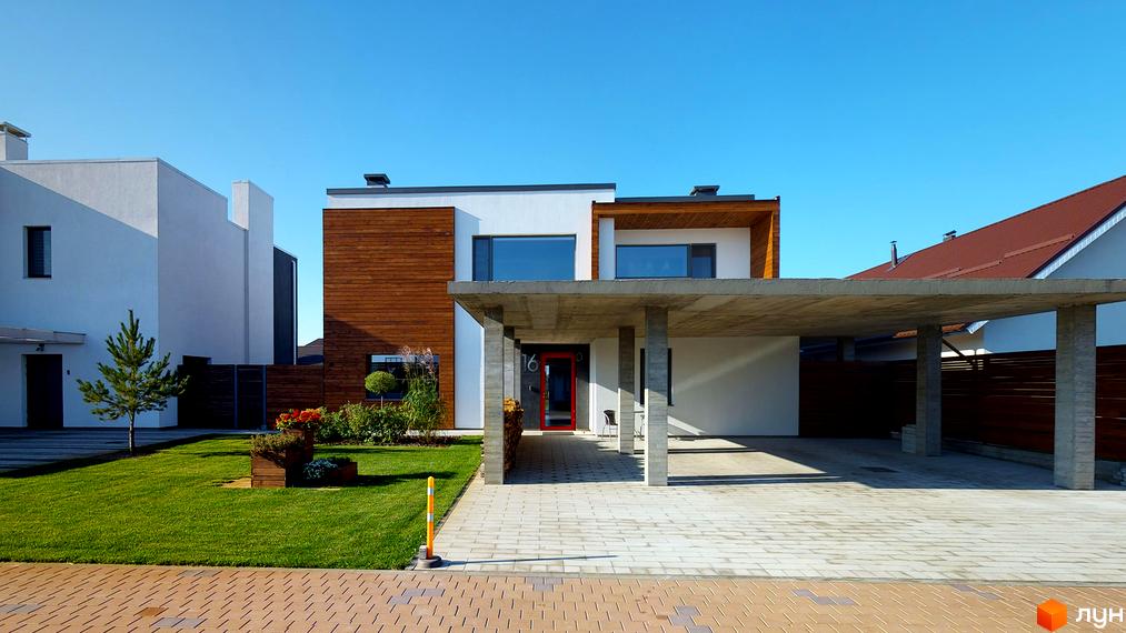 Котеджне містечко КМ На Щасливій: двоповерховий будинок з дерев'яними елементами та навісом для авто. Доглянута прибудинкова територія з газоном та квітами.