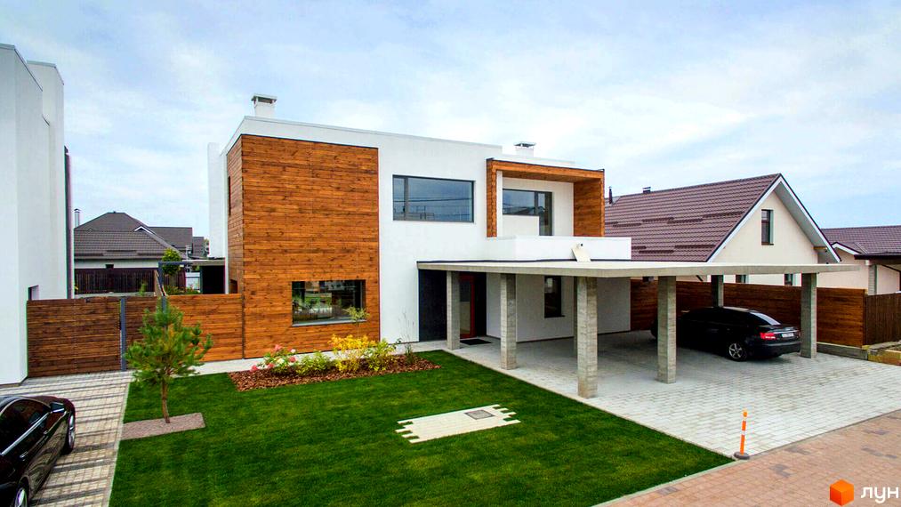 Котеджне містечко КМ На Щасливій. Зовнішній вигляд будинку з дерев'яним фасадом та навісом для авто. Прибудинкова територія з газоном та парканом.