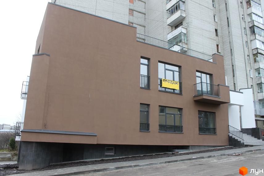 Фасад новобудови на вулиці Китайська, 14, з жовтим банером 