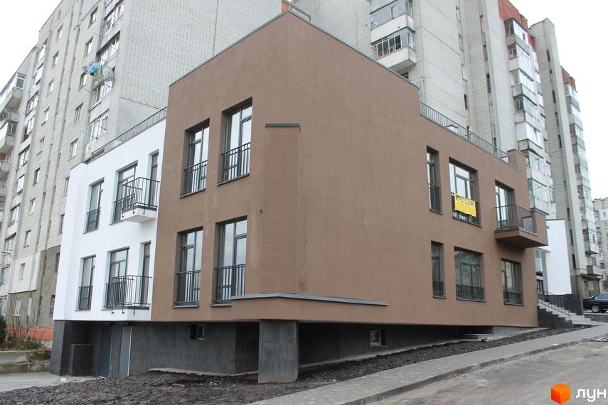 Новобудова на вулиці Китайська, 14. Будинок має коричневу та білу частини, з балконами та вікнами. Навколо будинку облаштована прибудинкова територія з тротуаром.