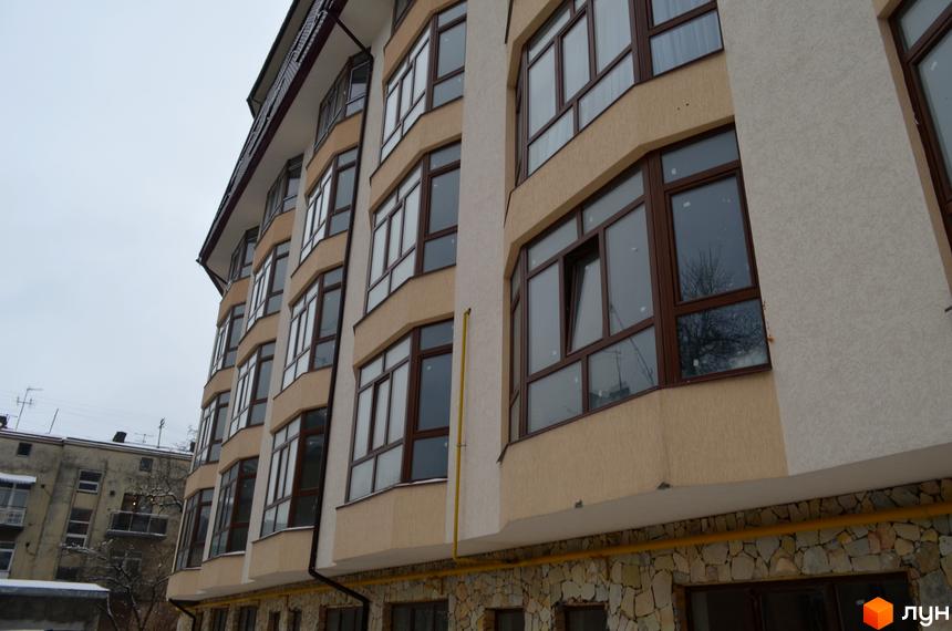 Зовнішній вигляд Житлового комплексу на вул. Гіпсова, 36в: багатоповерхова будівля з бежевим фасадом, великими вікнами та кам'яним цоколем.